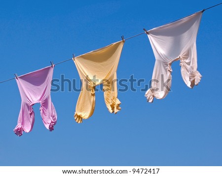 Shirts on the Line - ruffled shirts hang on line against blue sky