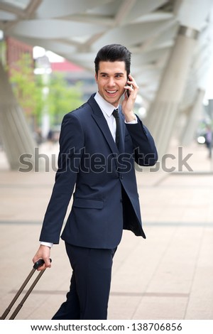 Portrait of a handsome businessman talking on phone and walking outdoors