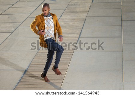 Portrait of a black male fashion model posing outdoors in casual clothes