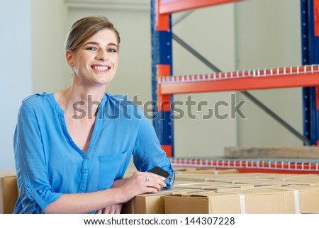 Portrait of a happy female employee smiling in warehouse