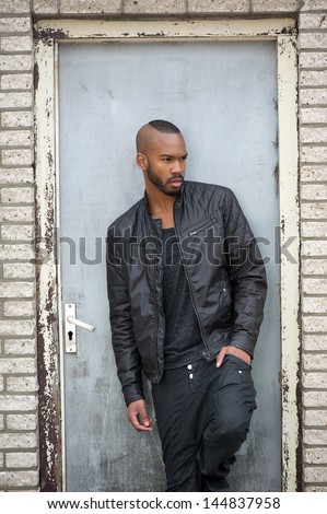Portrait of an attractive young black man standing in door way