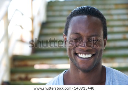 Closeup portrait of an african american man laughing with eyes closed