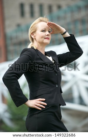 Portrait of a businesswoman with hand to head salute in the city