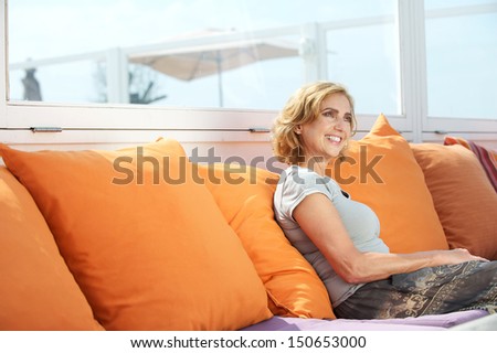 Closeup portrait of an attractive middle aged woman sitting on sofa outdoors