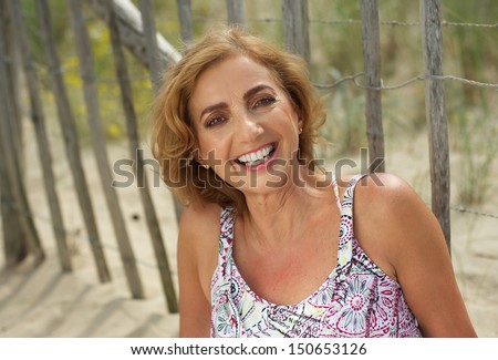 Closeup portrait of an attractive middle aged woman smiling outdoors
