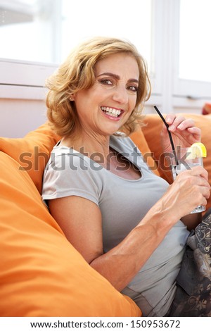 Closeup portrait of a happy woman relaxing with a drink of water at an outdoors restaurant