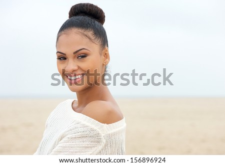 Close up portrait of an attractive young lady looking over shoulder and smiling