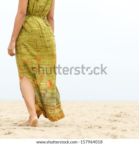 Portrait of a barefoot woman walking forward at the beach