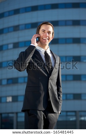 Portrait of a handsome young businessman calling by mobile phone outside the office