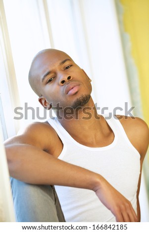 Close up portrait of a young man posing by window