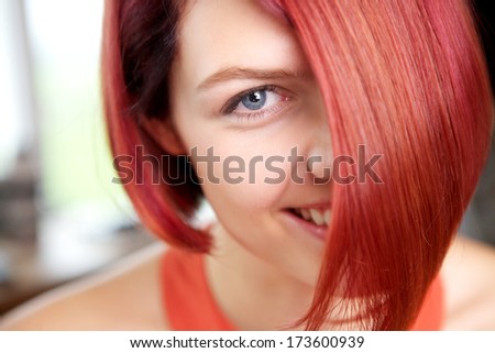 Close up portrait of a young woman with red hair and blue eyes smiling
