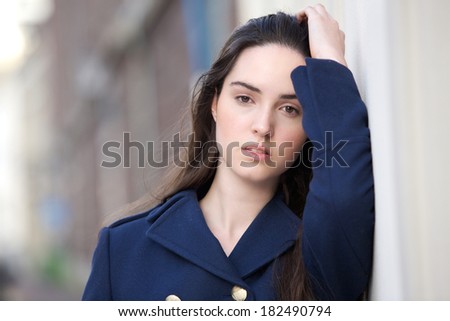 Close up portrait of a female fashion model posing outdoors with hand in hair