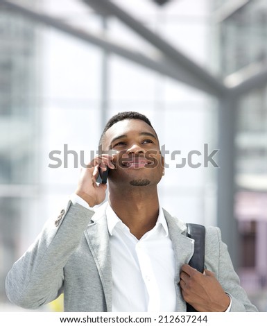 Close up portrait of a young african american man smiling with mobile phone