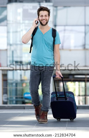 Portrait of a handsome young man talking on mobile phone with bag