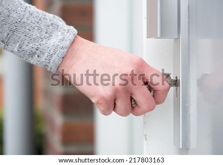 Close up side view female hand inserting key in door