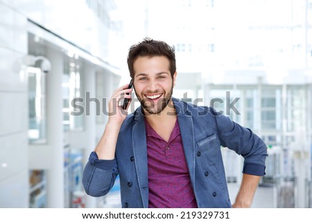 Portrait of a cool guy smiling with mobile phone