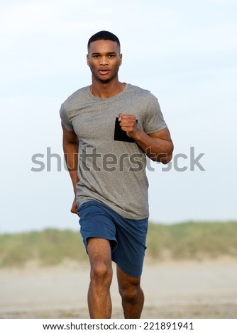 Healthy young black man running outdoors by the beach