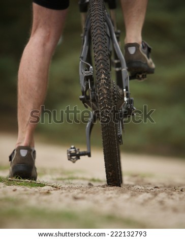 Rear view low angle man legs on mountain bike outdoors