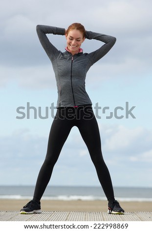 Happy sports woman smiling at the beach