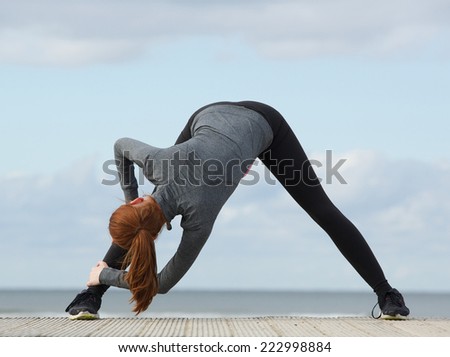 Young sporty woman bending down and stretching exercise