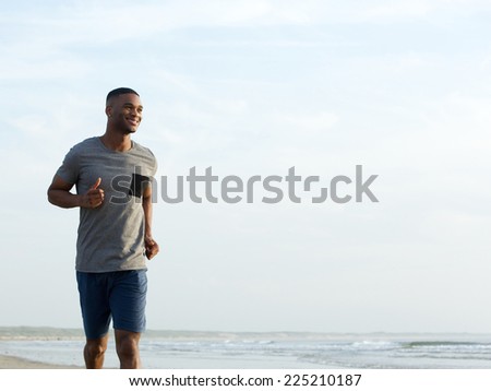 Active young man enjoying a jog at the beach