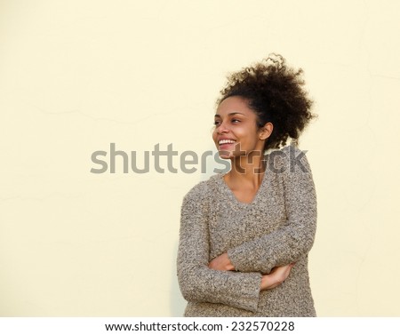 Portrait of a smiling young black woman with arms crossed