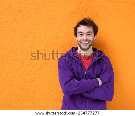 Portrait of a friendly guy smiling with arms crossed