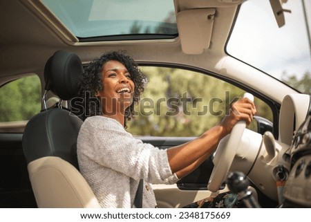 Similar – Image, Stock Photo Young smiling woman steering car at sunset