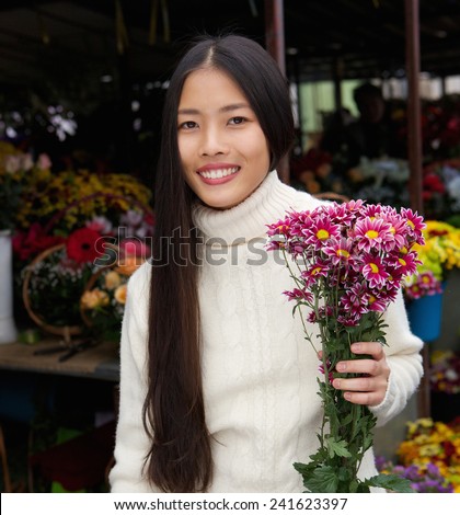 Close up portrait of a beautiful young asian woman smiling with flowers