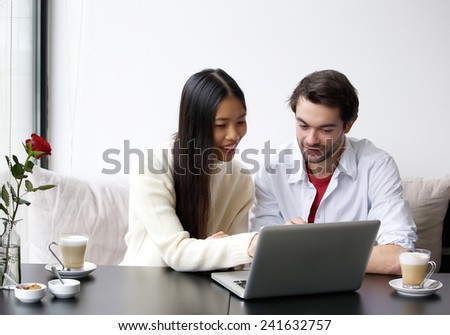 Portrait of a young couple looking at laptop