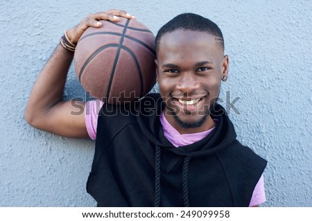 Close up portrait of a happy african american man smiling with basketball