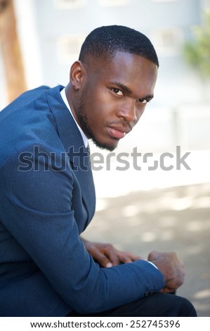 Side view portrait of a young african american businessman sitting outside