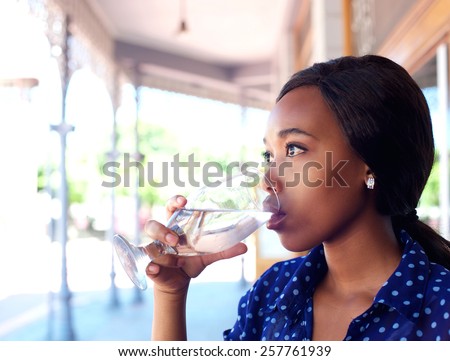 Close up profile portrait of a young business woman drinking water