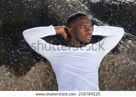 Close up portrait of a black male fashion model with white shirt posing outdoors