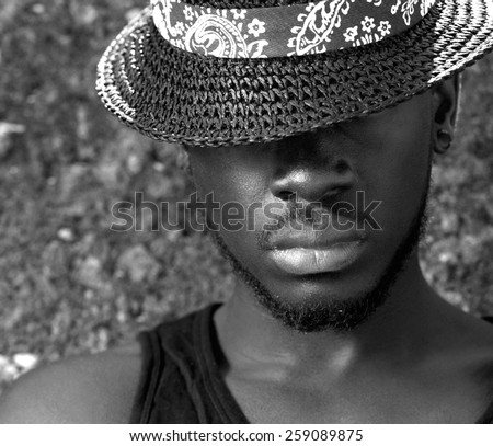 Black and white portrait of an african american man with hat covering face