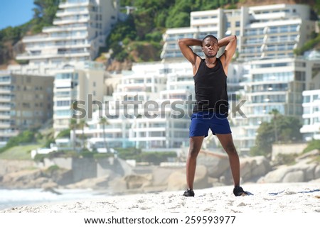 Full body handsome young sports man standing at the beach