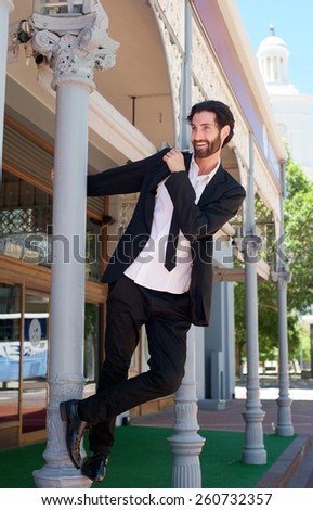 Portrait of a happy young man in business suit having fun outside