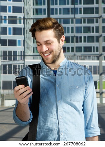Portrait of a handsome young man smiling with mobile phone at station