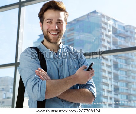 Portrait of a handsome young man smiling with mobile phone