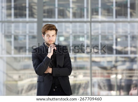 Portrait of a young businessman in black suit thinking