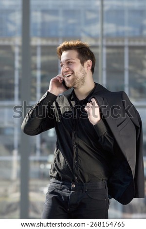 Portrait of a young man smiling with mobile phone in the city