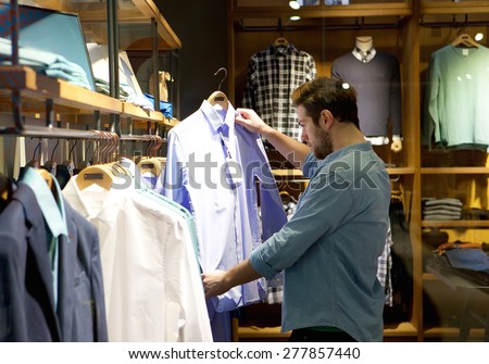 Portrait of a young man shopping for clothes at store