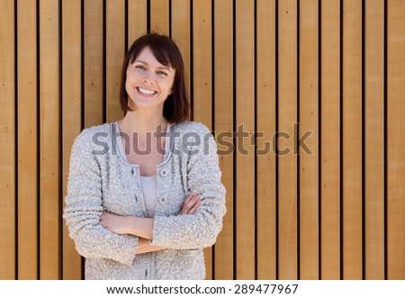 Close up portrait of a happy smiling middle aged woman standing with arms crossed