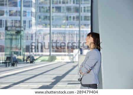 Side portrait of a happy business woman standing alone
