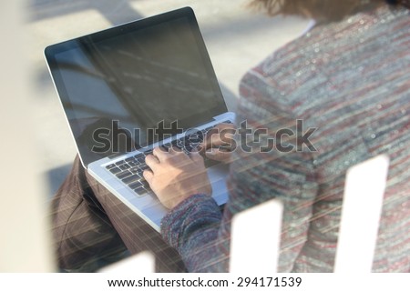 Portrait from behind of a woman using laptop outside