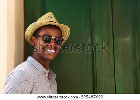 Close up portrait of a happy guy with hat and sunglasses