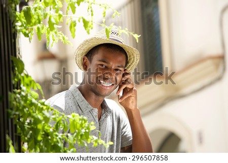 Portrait of a happy guy calling with mobile phone outside