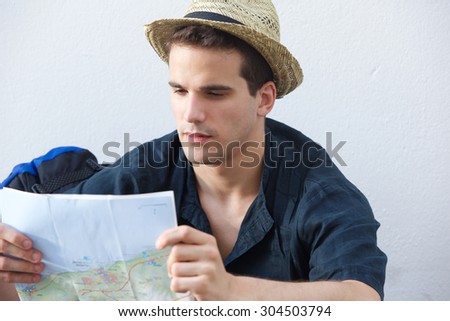 Portrait of a young traveling man reading map