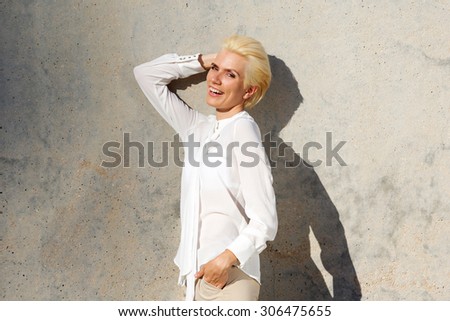 Portrait of a confident young woman laughing with hand in hair
