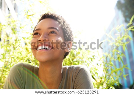 Photo of Close up portrait of beautiful young black woman smiling outdoors